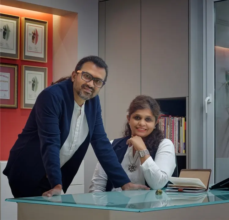 Sanjay and Mansi Newaskar in their studio, with award certificates on the wall behind them.