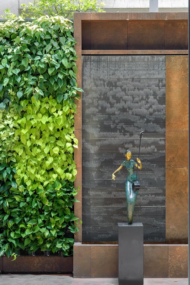 Cutting Edge House: vertical garden beside a dark rippled wall.