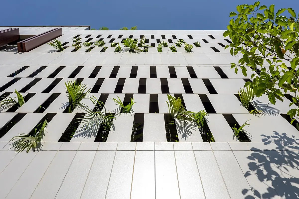 Cutting Edge House: facade panels with staggered, planted openings.