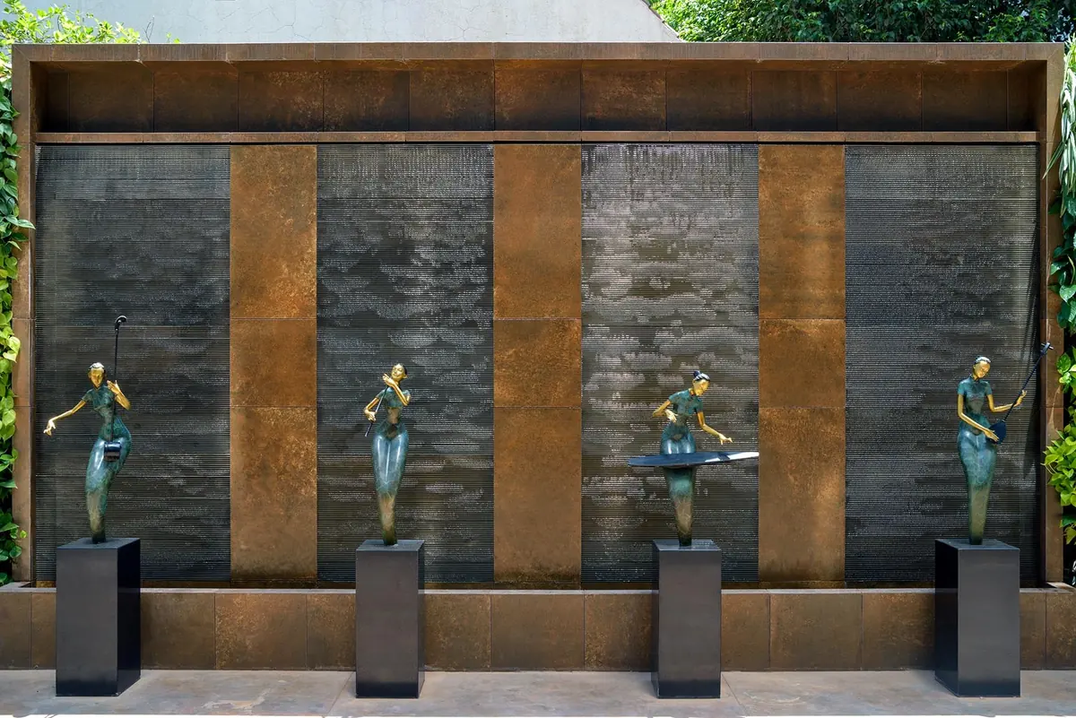 Cutting Edge House: courtyard wall: rust-toned panels and four sculptures.