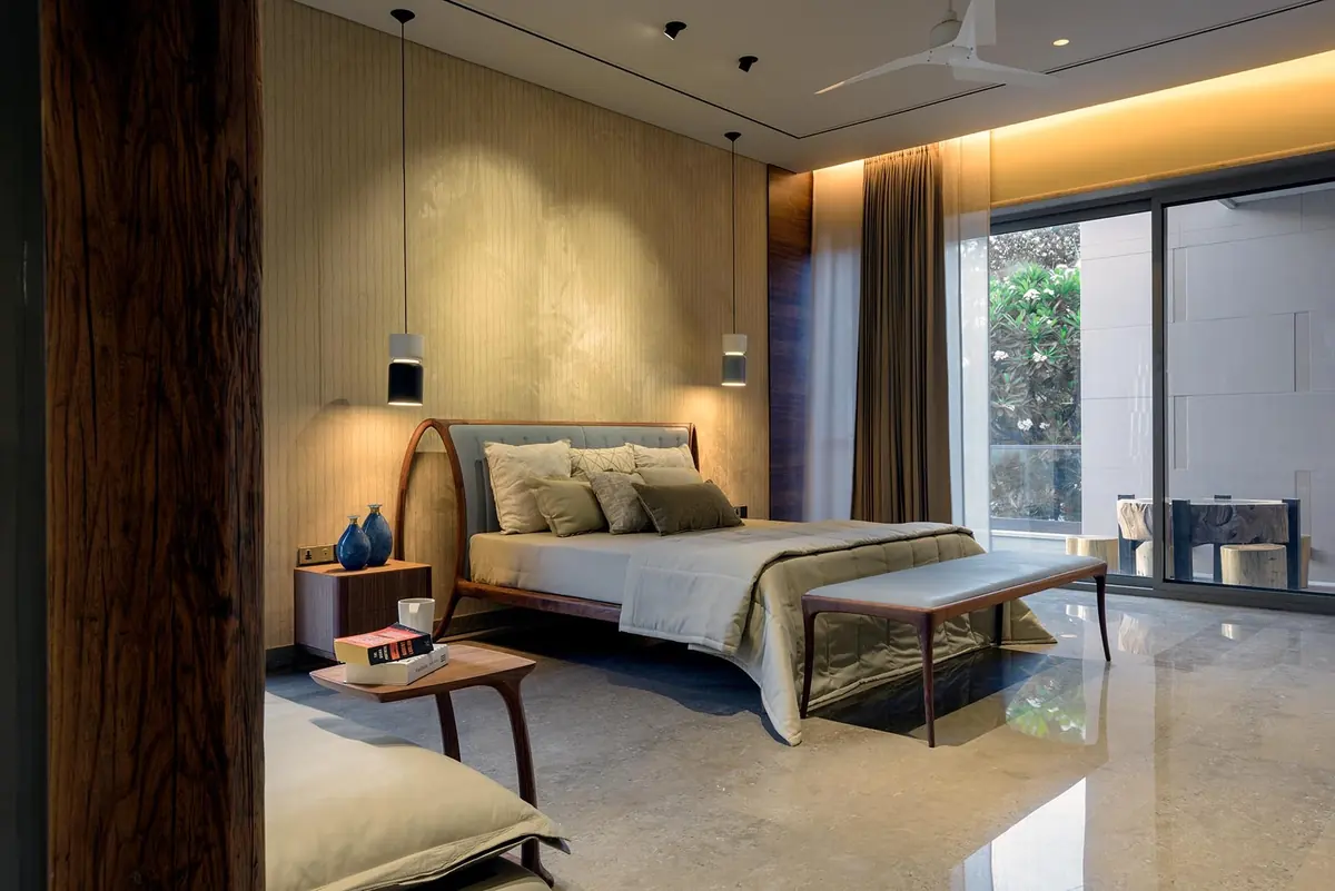 Cutting Edge House: bedroom with a timber wall and warm cove lighting.