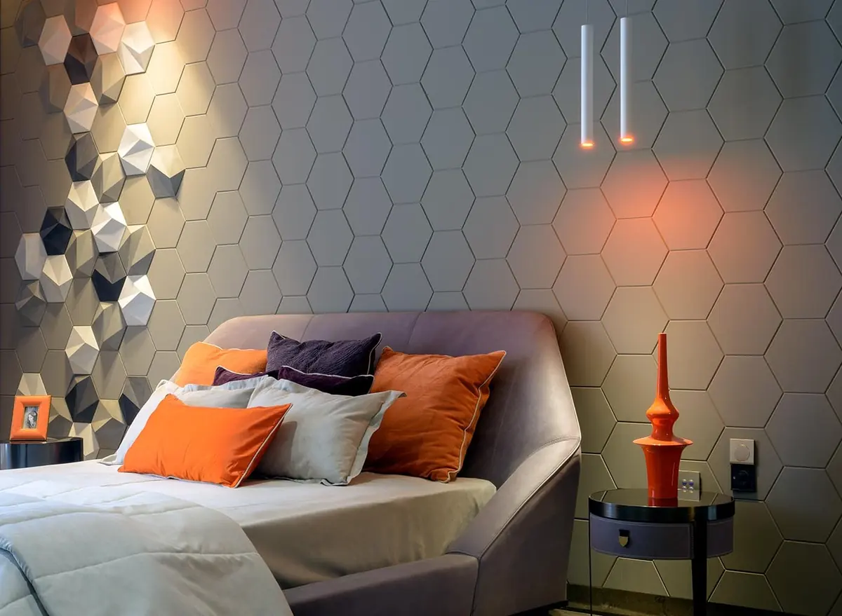 Cutting Edge House: bedroom with a hexagonal feature wall and orange cushions.