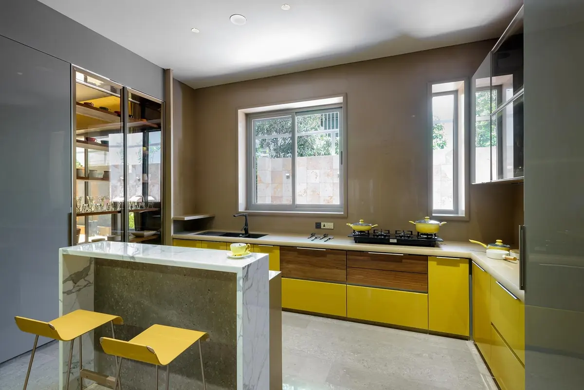 Cutting Edge House: kitchen with yellow cabinets and a breakfast counter.